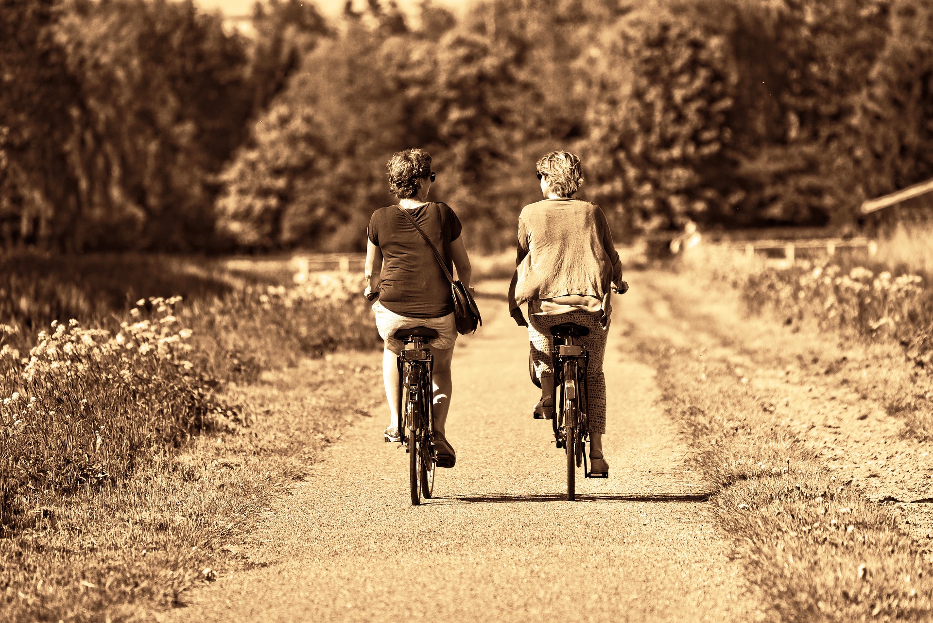 A couple riding a bike down a pathway.