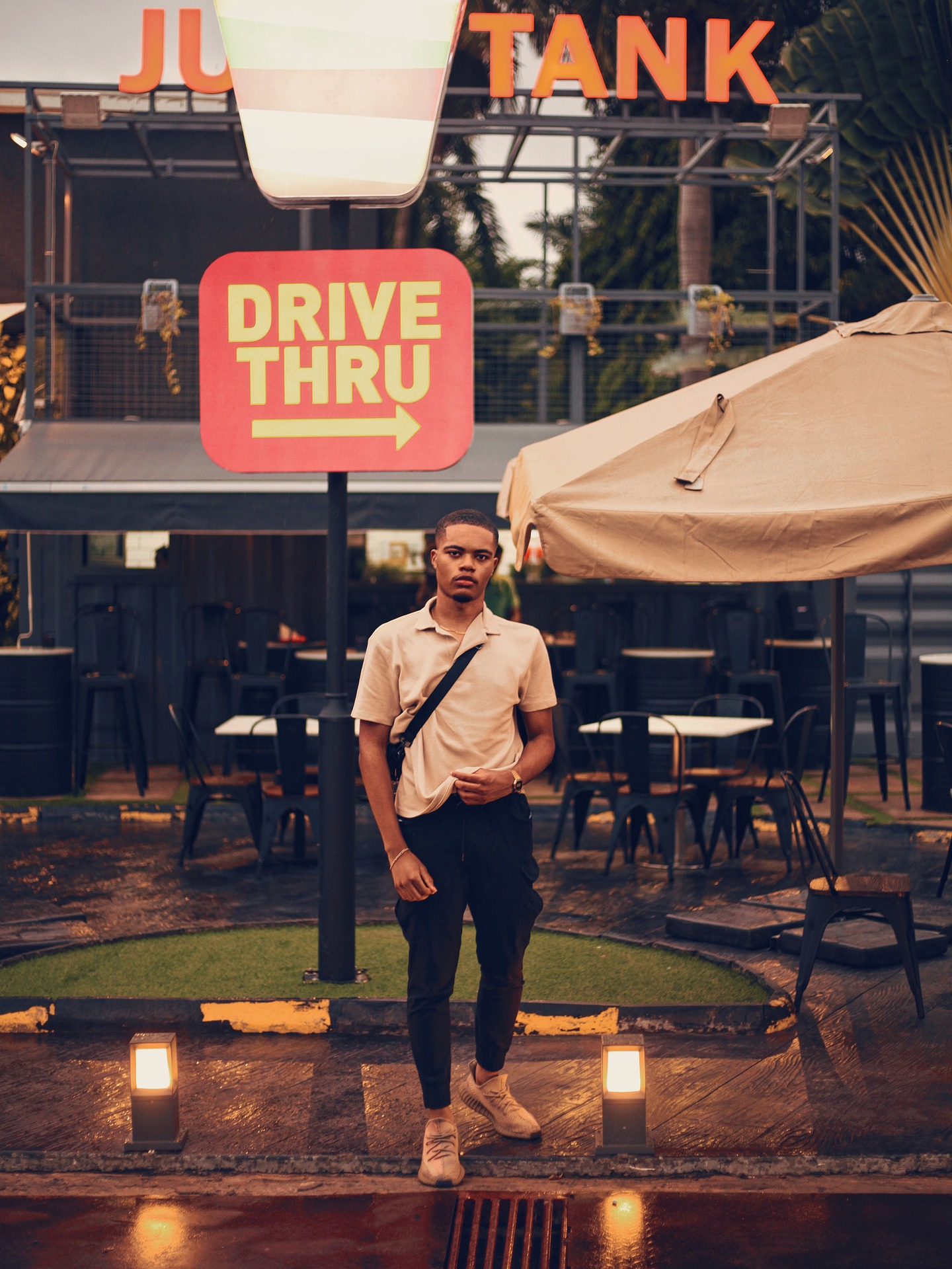 A man in front of the drive thru sign